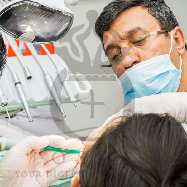 Dentist with Medical Assistant Taking Care of a Patient